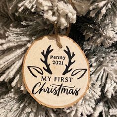 a wooden ornament hanging on a christmas tree with the words penny 2091 my first christmas