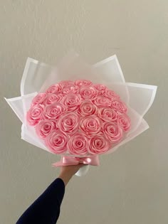 a hand holding a bouquet of pink roses