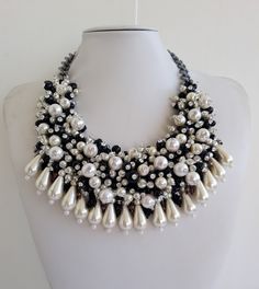 Each piece of our statement necklaces is handmade and one of a kind made in Italy. Our creations is made of high quality materials such as crystals and rhinestones. Each embroidered material is carefully hand sewn. Very glamorous and stylish. Perfect gift to someone you like. Materials Strass stones in Crystal color, and White and Black pearls in different dimension. Jeweled drop fringe in White pearl color.  Black satin fabric backing. Aluminium chain with lobster closure. Measurements Weight approximate 250 grams. Chain lenght 24 cm - 9,448 in Circumference approximate 59 cm - 23,22 in Feel free to contact us if you have any question. Thank you so much for looking at our shop and our articles each of them, single piece. Handmade Choker Bridal Necklace For Party, Handmade Bridal Choker Necklace, Handmade Bridal Choker Necklace For Party, Handmade Bridal Choker For Party, Beaded Pearl Crystal Necklace For Party, Handmade Crystal Necklaces For Parties, Pearl Beaded Crystal Necklace For Party, Handmade Crystal Choker Necklace For Party, Stylish Silver Crystal Necklace