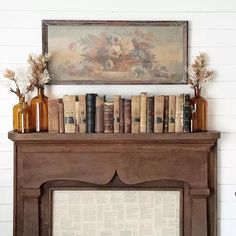 an old fireplace with books and vases on top