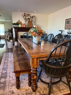 a dining room table and chairs in front of a fireplace