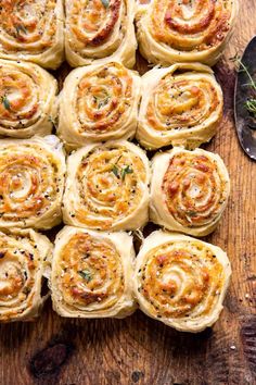 a wooden table topped with rolls covered in cheese