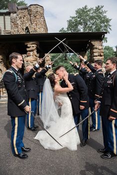 a bride and groom kissing in front of their wedding party