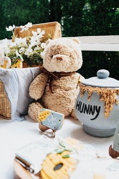 a teddy bear sitting on top of a table next to a potted plant and other items