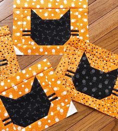 four pieces of quilted fabric with black cats on orange and white polka dotty