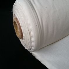 a roll of white fabric sitting on top of a black surface