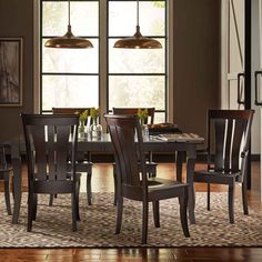 a dining room table and chairs in front of a window with an area rug on the floor