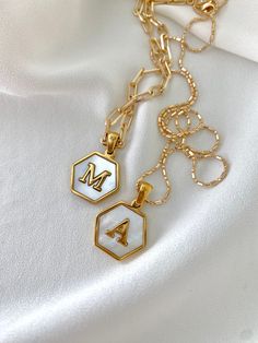 **Each piece in my shop, I personally create and photograph. (All photos are property of The Cord Gallery LLC) Thank you for supporting my small business.Gold Mother Of Pearl Letter Necklace - Hexagon ShapeAdd a personal touch to your accessories collection with these stunning Letter Necklaces.Features a high quality Hexagon Shaped Letter Charm set in stunning Mother of Pearl. Pendants are gold stainless steel and are adorned on your choice of chain.Pendants measure approximately 23.8 x 16.8mmCh White Chain Link Jewelry Gift, White Chain Link Jewelry For Gift, White Link Necklace For Gift, White Chain Link Necklace Gift, White Chain Link Necklace As A Gift, White Chain Link Necklaces For Gifts, White Chain Link Necklace For A Gift, Initial Pendant Paperclip Chain Necklace, White Link Chain Necklace Gift