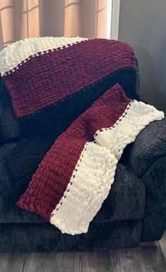 a crocheted blanket sitting on top of a couch next to a black chair