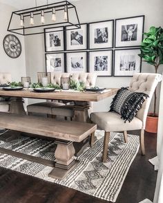 a dining room table and chairs with pictures on the wall above it, along with an area rug