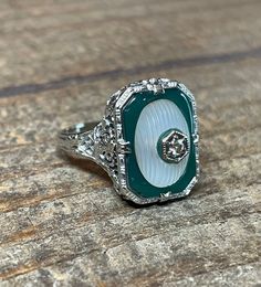 This exquisite Art Deco piece is set in solid 14 karat white gold and weighs 4.2 grams. An amazing and unique design with carved green chrysoprase around camphor glass with a diamond in the center. This ring is a size 7 1/2 (note it fits more like an 8 due to design) and measures 17 mm across the top. The filigree is absolutely stunning and in fabulous condition. The center diamond weighs approx. .05 carat and note the small round piece of chrysoprase set just underneath the diamond... the atten Antique Filigree, Antique Ring, Filigree Ring, Antique Rings, Cut Glass, Stripes Design, Rings Statement, Statement Rings, Unique Design