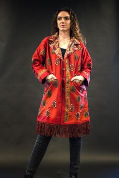 Harriet - a stunning red silk jacket, handcrafted to make you the star of the show. It's an upcycled piece made from a vintage silk traditional Indian garment, embellished with beautiful stones, and adorned with a collar, fleece lining, and leather fringes.  Step out in style and make a statement with Harriet!  More on this jacket: - Unique: Every jacket we up-cycle is one-of-a-kind, enabling you to highlight your individuality and unique style.  - Handmade: This piece is handmade with lots of love and attention to detail, the jacket features beautiful silk embroidery and stone work, adding a touch of luxury and sophistication.   Measurements: Chest: 21" Length with fringe: 38" Length without fringe: 33" Sleeves: 21"   Care instructions: Dry clean Free return on this jacket. Try it and if Festive Long Sleeve Silk Outerwear, Fitted Red Outerwear For Festival, Embellished Red Outerwear For Fall, Traditional Embellished Outerwear For Fall, Embellished Silk Outerwear, Red Embellished Outerwear For Fall, Red Bohemian Outerwear For Festival, Bohemian Silk Winter Outerwear, Embellished Long Sleeve Silk Outerwear