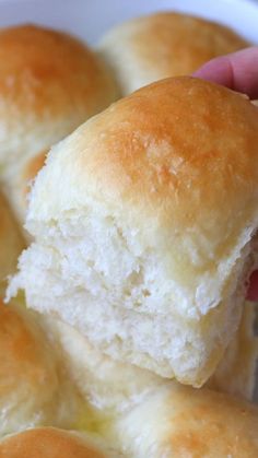 a person is holding a piece of bread in their hand while they are eating it