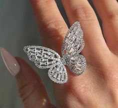 Embrace elegance and whimsy with our Cubic Zirconia Crystal Studded Butterfly Ring. This exquisite piece is a must-have for jewelry lovers who appreciate the delicate beauty of nature combined with a touch of sparkle. Available in three stunning platings - Gold, Rose Gold, and Silver - this ring is designed to complement any outfit and occasion. Key Features: Dazzling Design: The butterfly shape is meticulously crafted and adorned with brilliant cubic zirconia crystals, creating a sparkling effe Butterfly-shaped White Gold Jewelry For Wedding, Luxury Butterfly Ring With Brilliant Cut For Wedding, White Gold Butterfly Jewelry For Wedding, Fine Jewelry Butterfly Shape For Wedding, Delicate Butterfly Jewelry With Cubic Zirconia, Delicate Butterfly-shaped Jewelry With Cubic Zirconia, Luxury Butterfly Ring With Cubic Zirconia, Fine Jewelry Butterfly Piece For Wedding, Delicate Butterfly Cubic Zirconia Jewelry