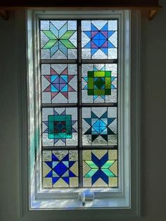 a close up of a stained glass window in a room with white walls and wood trim