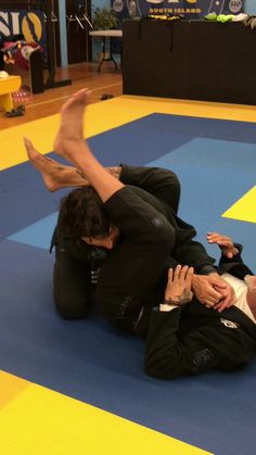 two men in black suits and white shirts are wrestling