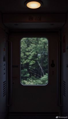 the inside of an empty train car with trees in the background and a window on one side