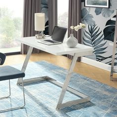 a white desk with a laptop on it in front of a blue rug and window