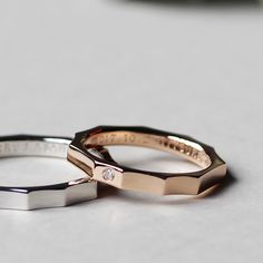 two wedding rings sitting on top of a table