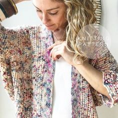 a woman with long hair wearing a colorful cardigan