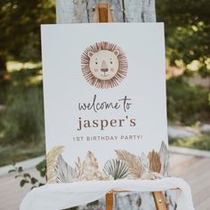 a welcome sign for a 1st birthday party with a lion head on it and palm leaves