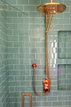 a shower head and hand held shower faucet in a bathroom with blue tile