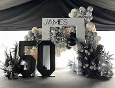 an entrance to a party with balloons and decorations on the floor, including a sign that says james