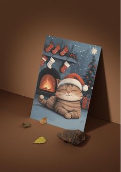 a christmas card with a cat sitting in front of a fireplace and stockings on it