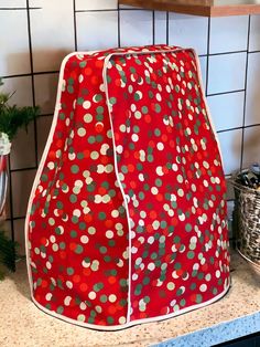 a red and green polka dot covered oven mitt sitting on top of a counter