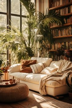 a living room filled with lots of furniture and plants on the wall next to large windows