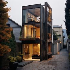 a modern house is lit up at night in the evening, with its windows open