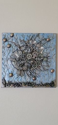 a blue and silver wall hanging on the side of a white wall