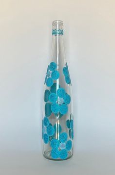 a glass bottle with blue flowers in it