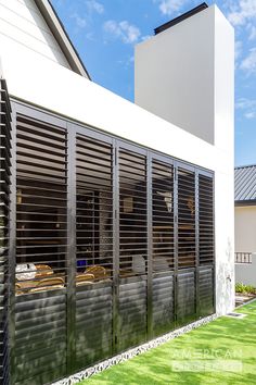 an outside view of a house with wooden slats on the windows and shutters