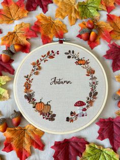 an embroidered autumn wreath surrounded by leaves and acorns