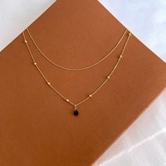 Minimalist and chic, it's perfect as a gift! This necklace goes very well with other gold necklaces. Women's necklace with a fine beaded chain and a small tear-shaped stone that is a black onyx, and a shorter chain. Chain Material: Stainless Steel • Natural stone: onyx Height of the stone: 7mm • Length of the chain: 39cm and 45cm + 5cm of adjustment chain. Minimalist Black Double Chain Necklace, Elegant Necklace With Beaded Chain And Teardrop Pendant, Black Double Chain Necklace As Gift, Elegant Teardrop Pendant Necklace With Beaded Chain, Black Double Chain Necklace For Gift, Minimalist Black Teardrop Pendant Necklace, Minimalist Black Necklace With Satellite Chain, Elegant Onyx Teardrop Necklaces, Elegant Onyx Teardrop Necklace