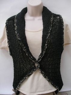 This vest was hand knit in a lace pattern. A black, gold and silver metallic yarn was used to edge the vest including the collar. A decorative silver button is used to close the front. This unique vest has a 3 inch long collar knitted into it. The size of this vest is a  Small /Medium, but is very stretchy due to the way it was knit, so that could effect the way it fits. The bust measures 36 inches. The length of the back is 26  inches long and it hangs down lower than the front , which is only Elegant Black Knit Sweater Vest, Fitted Black Knitted Sweater Vest, Vest With Collar, Unique Vest, Gold Vest, Black Knitted Vest, Vest Knitted, Beige Purses, Metallic Yarn