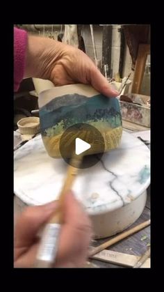 a person is painting on a marble slab