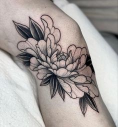 a black and white flower tattoo on the arm