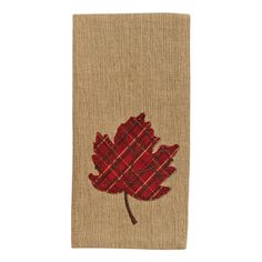 a red leaf is embroidered on the side of a burlocked book cover