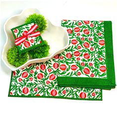 two pieces of green and red placemats sitting on top of a white plate