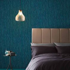 a bedroom with blue wallpaper and a brown headboard