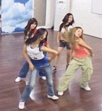 four young women are dancing in an empty room