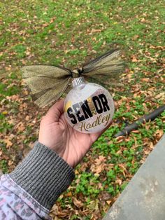 someone holding up a glass ornament with the word sem - do today on it