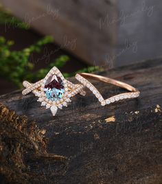 two diamond and blue topazte rings sitting on a piece of wood