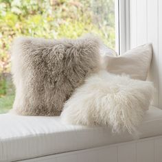 two pillows sitting on top of a window sill