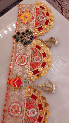 the table runner is decorated with gold, red and green designs on it's sides