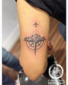 a person with a compass tattoo on their leg and the other hand is holding an object