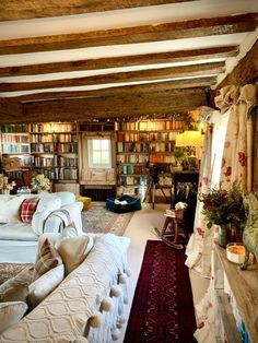 a living room filled with lots of furniture and bookshelves covered in bookcases