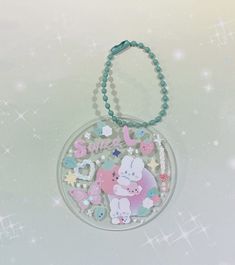 a keychain with an animal design on it's side and beads hanging from the front